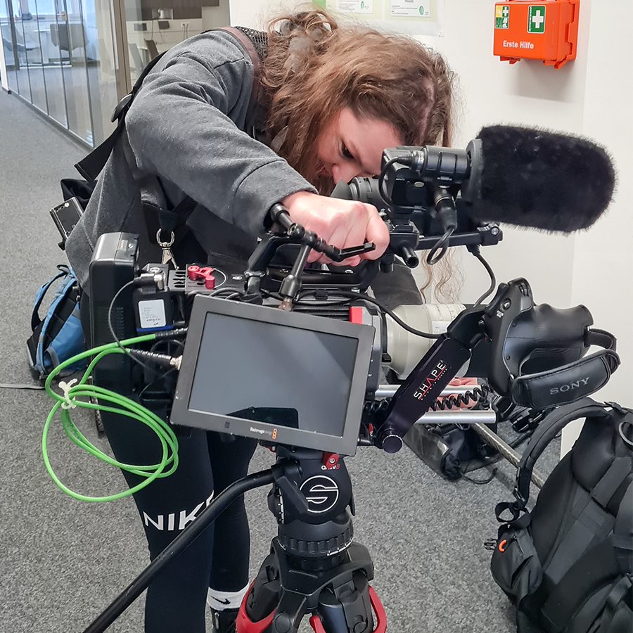 Kamera-Assistentin baut die Kamera auf. 